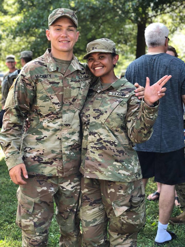 two cadets at ease smiling and waving